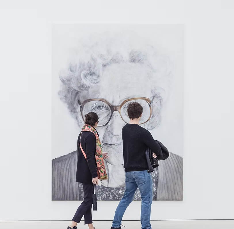 Žmonės, žiūrintys į reklamą ant sienos